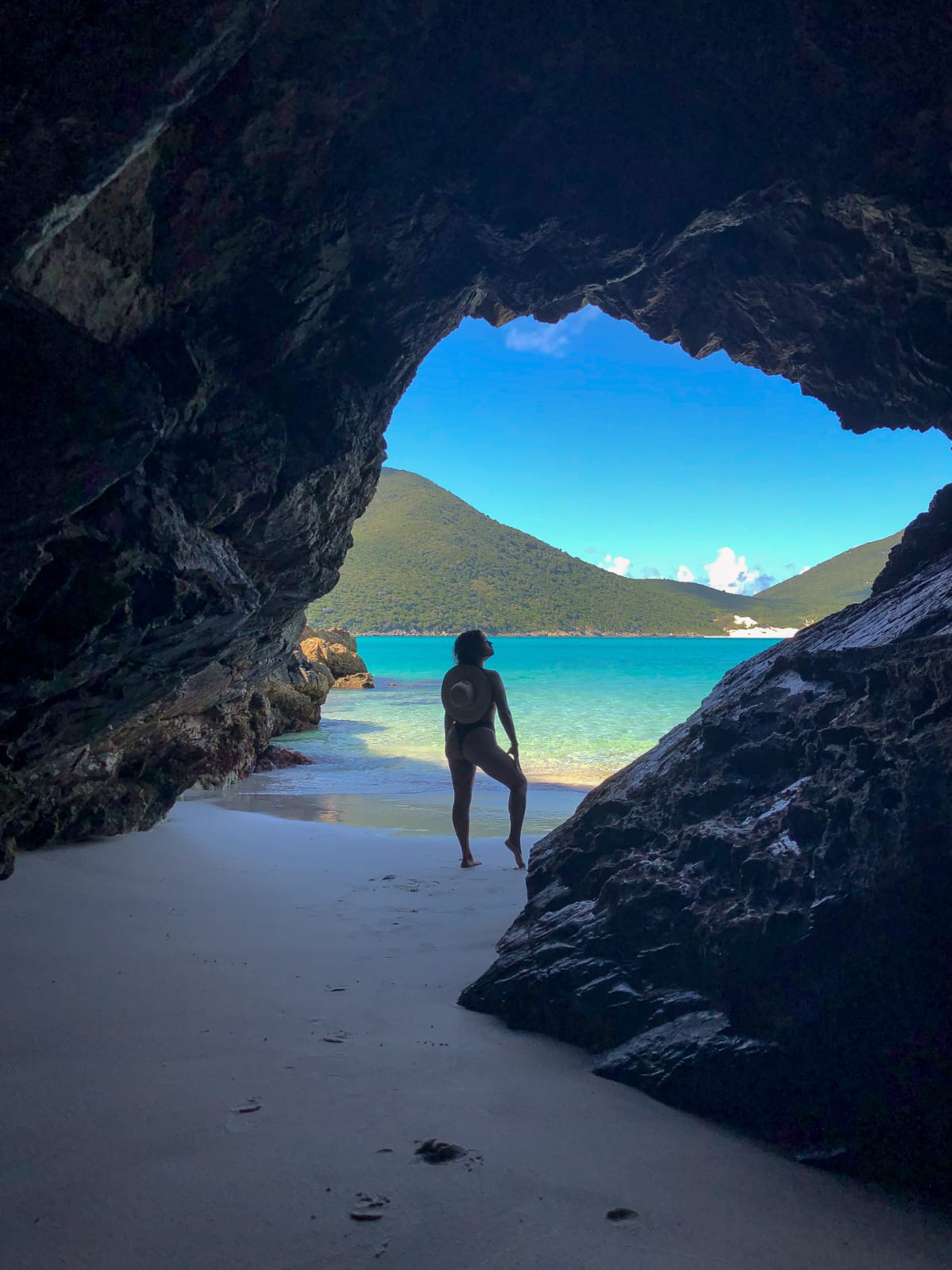 Pessoa explorando caverna na praia